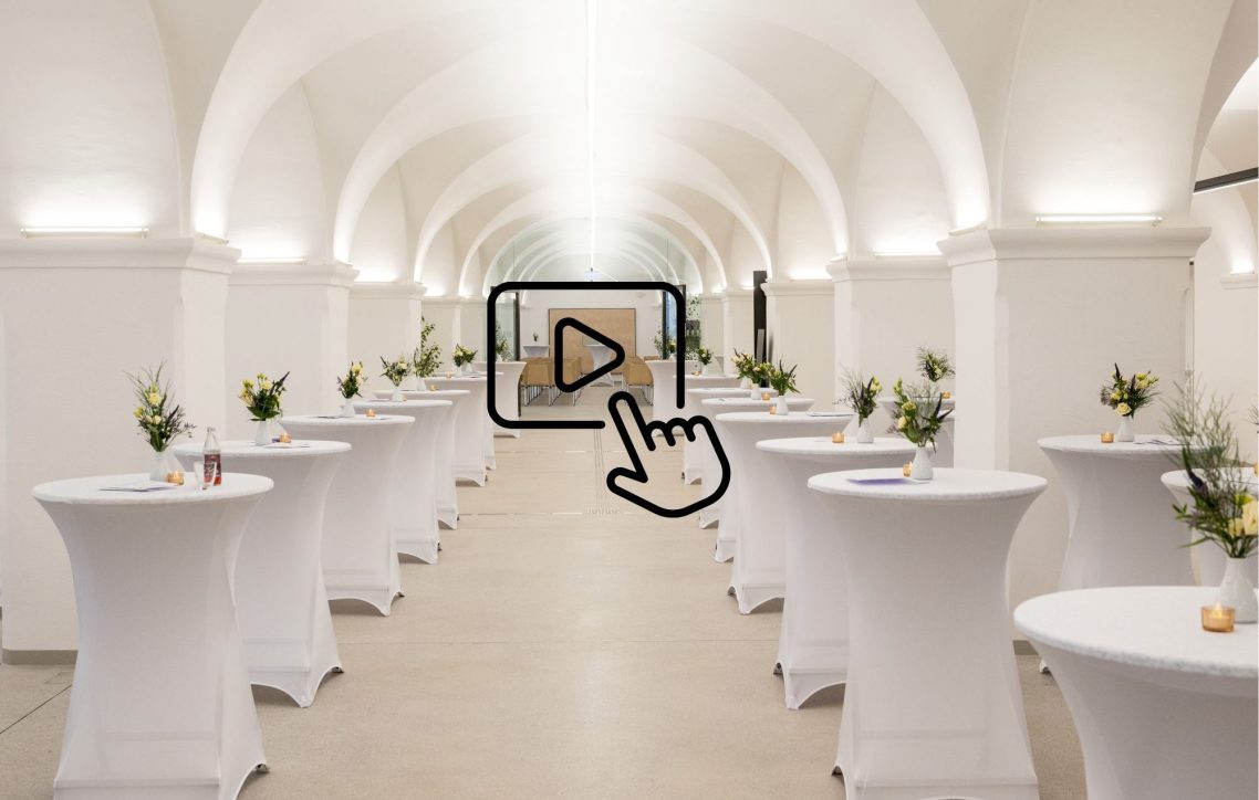 Haupteingang Kornhaus Haupteingang mit Bogen, Pflanzen und beleuchtetem Innenbereich.